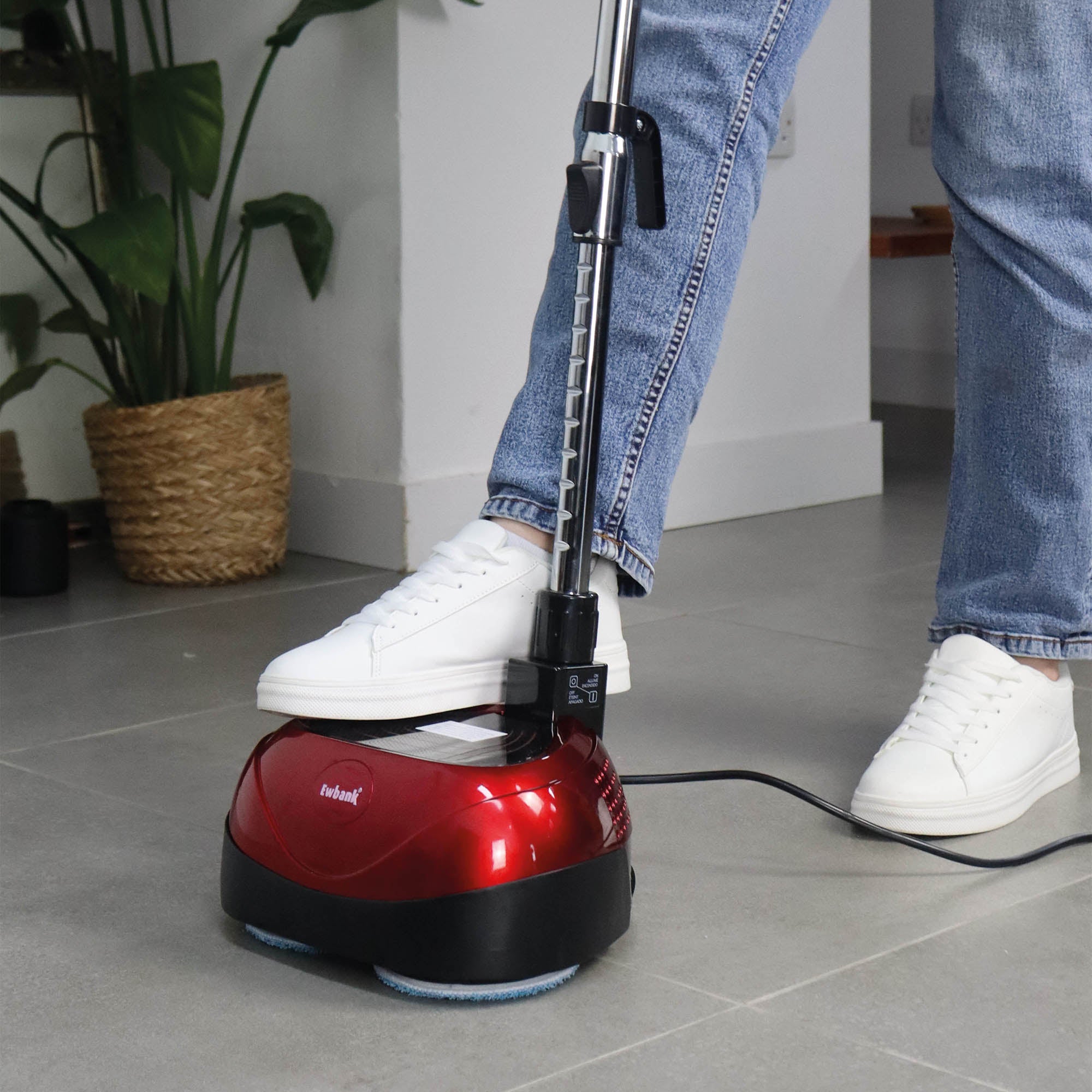 Wearing blue jeans and white sneakers, a person uses the EP170 Multi Use 3-in-1 Floor Cleaner & Polisher on a gray tile floor, with a green potted plant seen in the background.