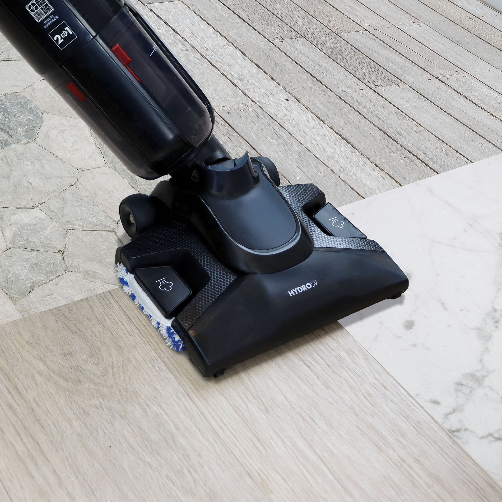 A close-up of a black Ewbank HYDROSV 2-In-1 Steam Vacuum Cleaner seamlessly cleaning stone, wood, and tile floors for effective multi-surface cleaning.