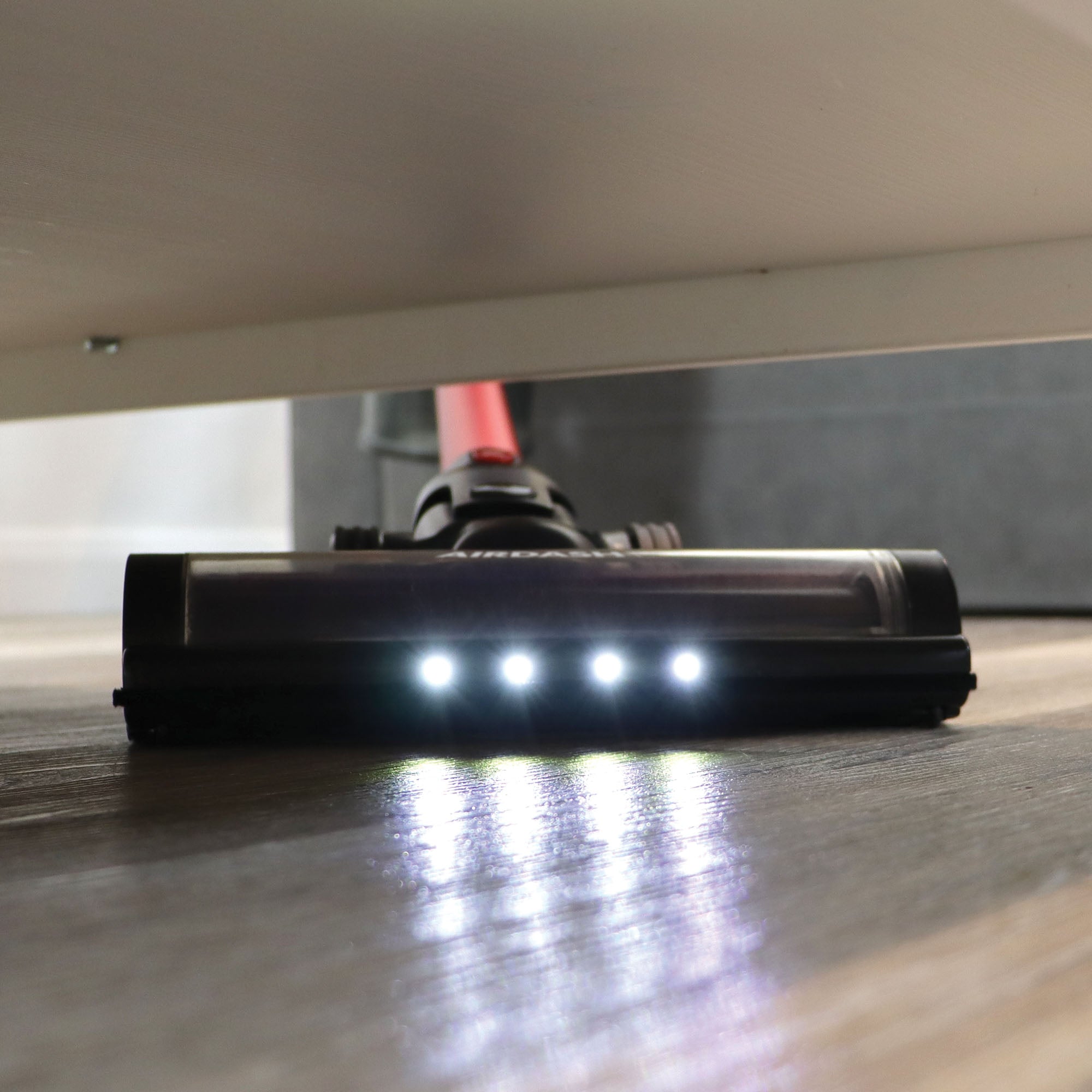 The AIRDASH 2-In-1 Cordless Stick Vacuum Cleaner, featuring built-in LED lights, effortlessly cleans under furniture and brightens up hard-to-see areas in dimly lit rooms.