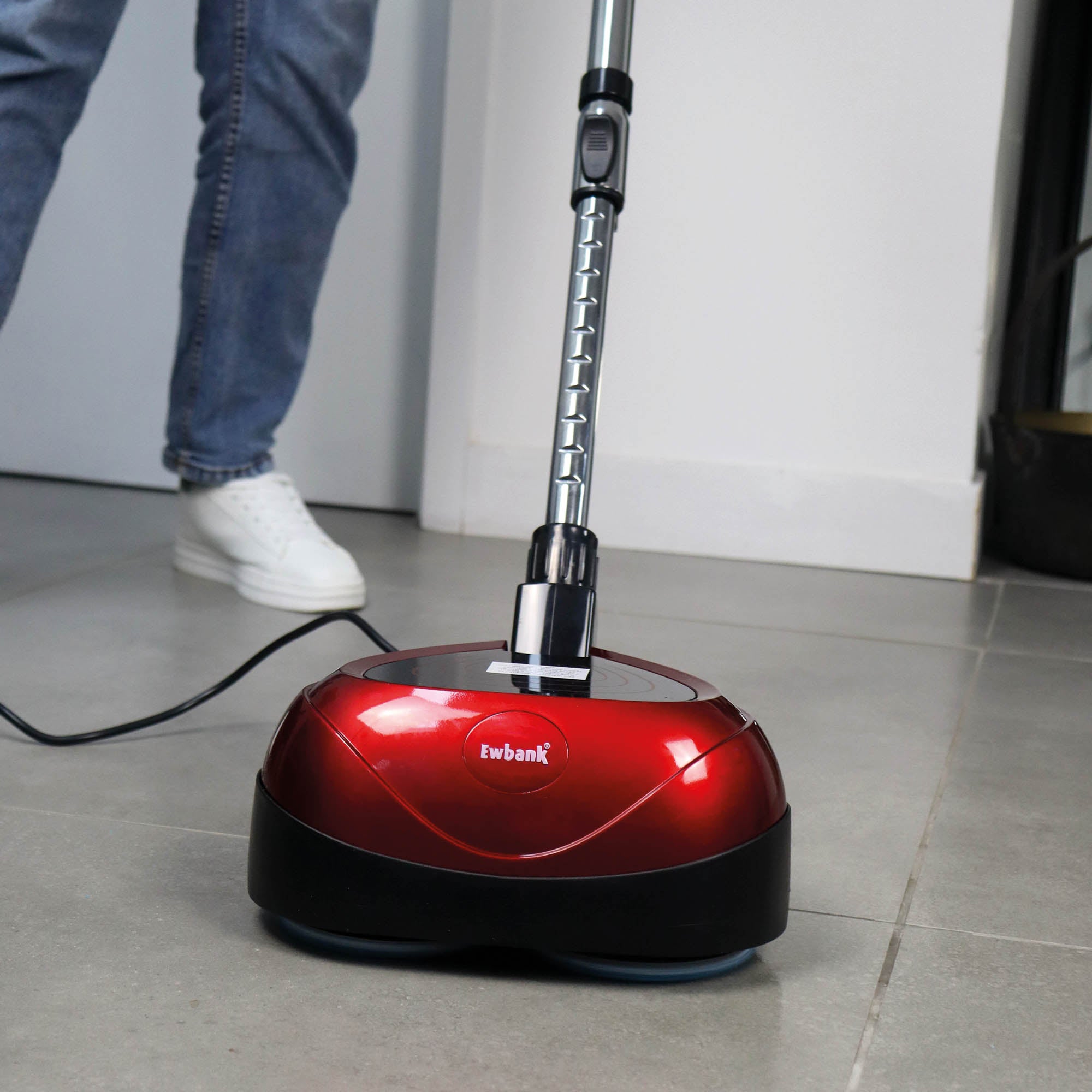 Wearing blue jeans and white sneakers, a person uses the EP170 Multi Use 3-in-1 Floor Cleaner & Polisher—a red and black, professional-grade machine—on tiled floors for spotless results.