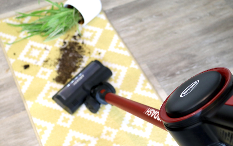 AIRDASH1 vacuum cleaning up soil from a dropped plant on rug