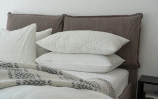 A close-up of white pillows stacked on a bed